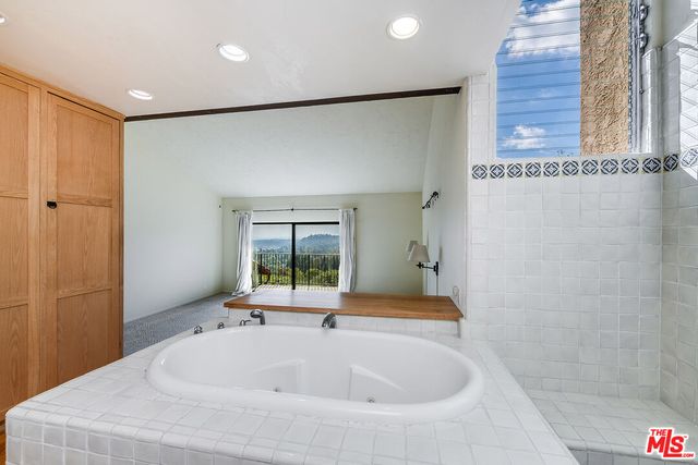 a bathroom with a tub sink and mirror