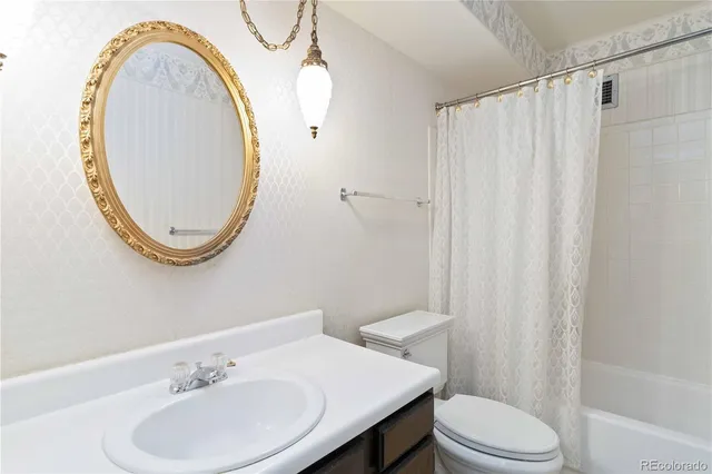 a bathroom with a sink mirror and toilet