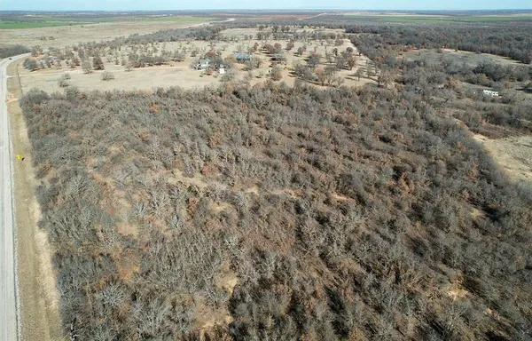 a view of a field with trees in the background