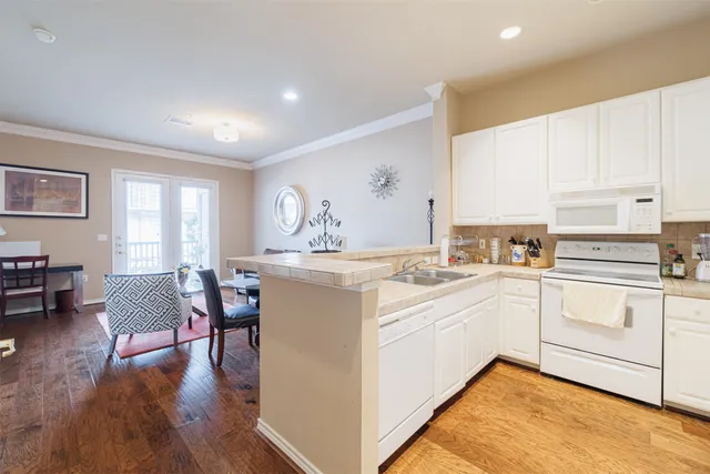a kitchen with a white cabinets and chairs