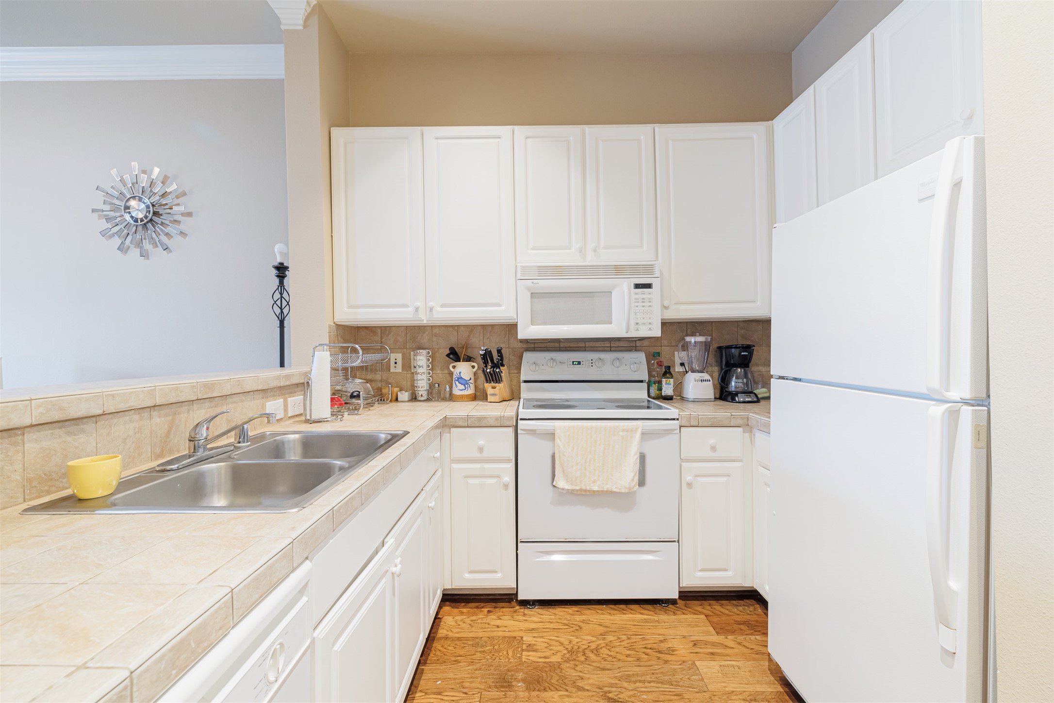 2400 McCue Road, Unit 144 Houston, TX 77056 - Photo 2 of 24 a kitchen with a refrigerator sink and white cabinets