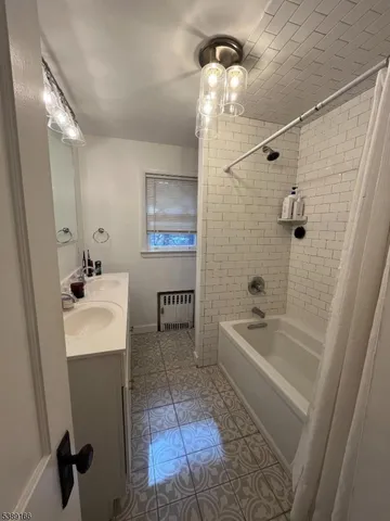 a bathroom with a sink a toilet a tub and shower