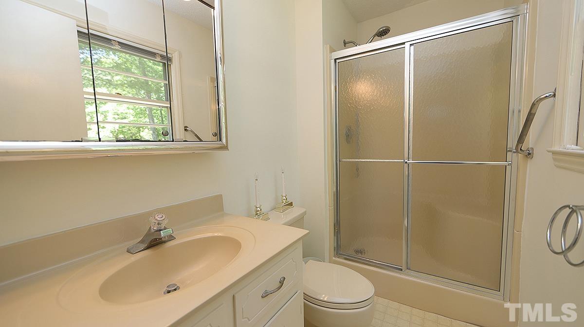 720 Torredge Road Durham, NC 27712 - Photo 13 of 17 a bathroom with a shower sink vanity mirror and toilet