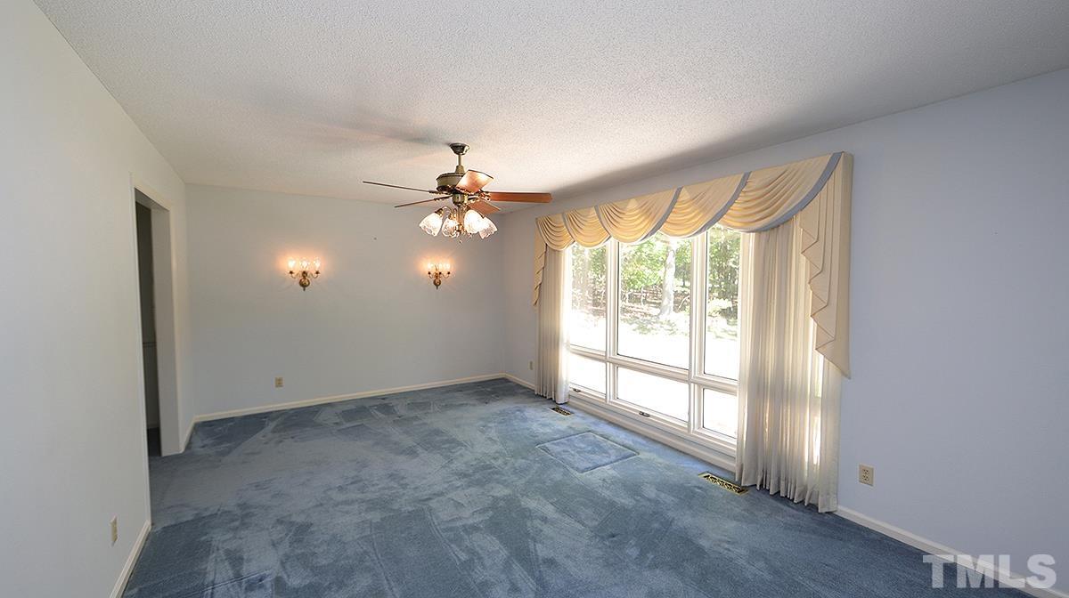 720 Torredge Road Durham, NC 27712 - Photo 3 of 17 an empty room with windows and chandelier fan