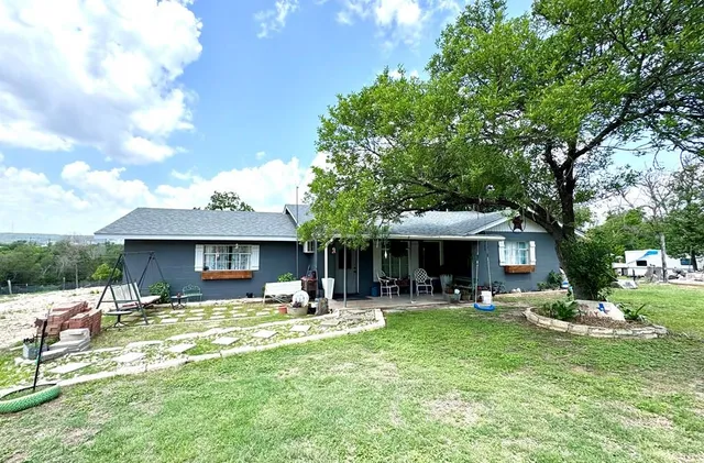 a front view of a house with garden and trees