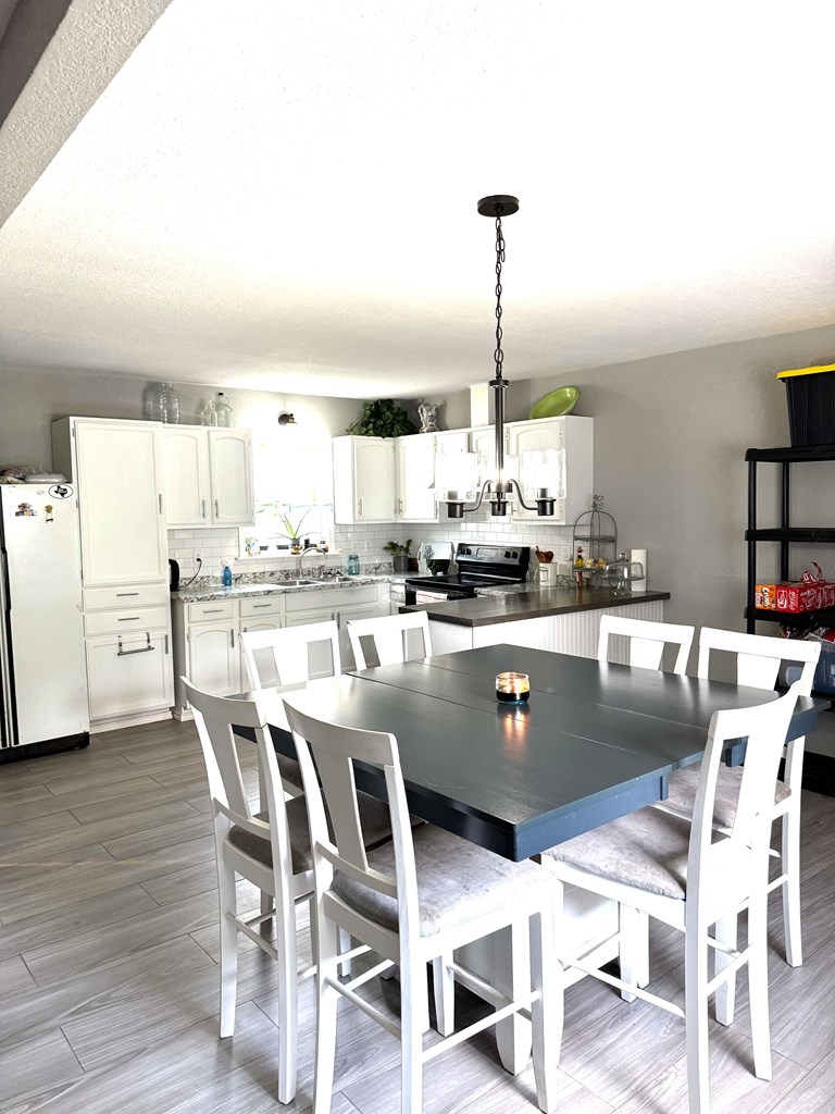 212 Way Drive Ingram, TX 78025 - Photo 11 of 22 a kitchen with stainless steel appliances kitchen island granite countertop a dining table chairs and white cabinets