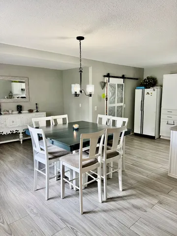 a dining room with furniture a chandelier and wooden floor