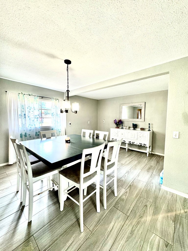 212 Way Drive Ingram, TX 78025 - Photo 9 of 22 a dining room with furniture a chandelier and wooden floor