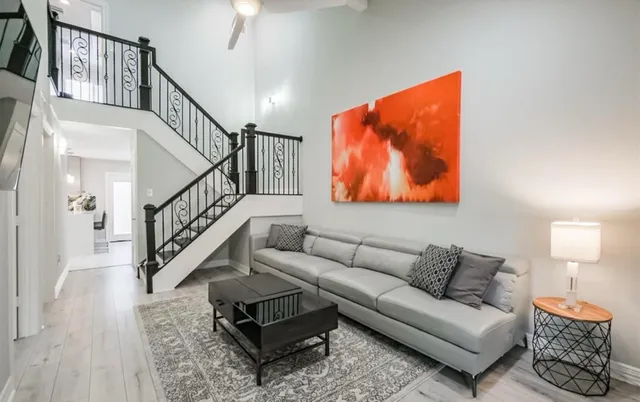 a living room with furniture and a lamp with wooden floor