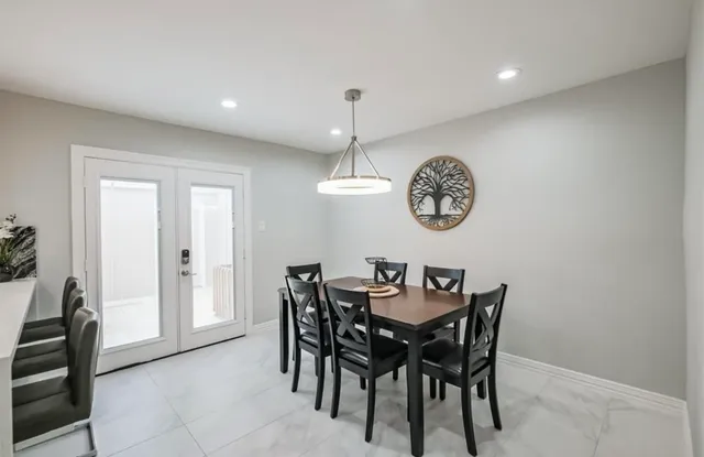 a kitchen with a table chairs and white cabinets