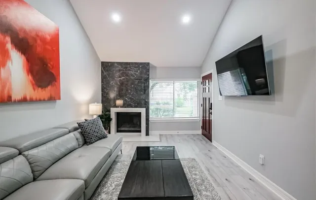 a living room with furniture a flat screen tv and a fireplace