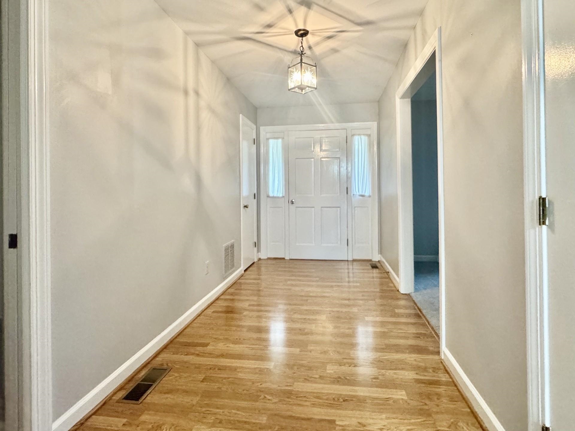81 Middlebrook Street Harrisonburg, VA 22801 - Photo 3 of 22 a view of a hallway with a chandelier fan and wooden floor