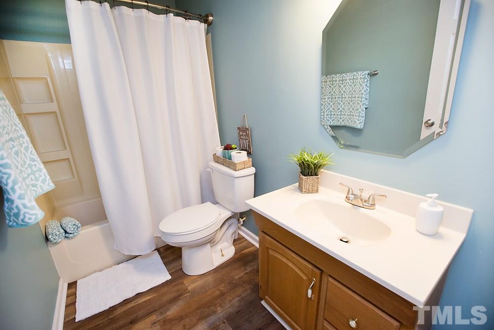 2225 Springhill Avenue Raleigh, NC 27603 - Photo 13 of 18 a bathroom with a sink a toilet and shower curtain