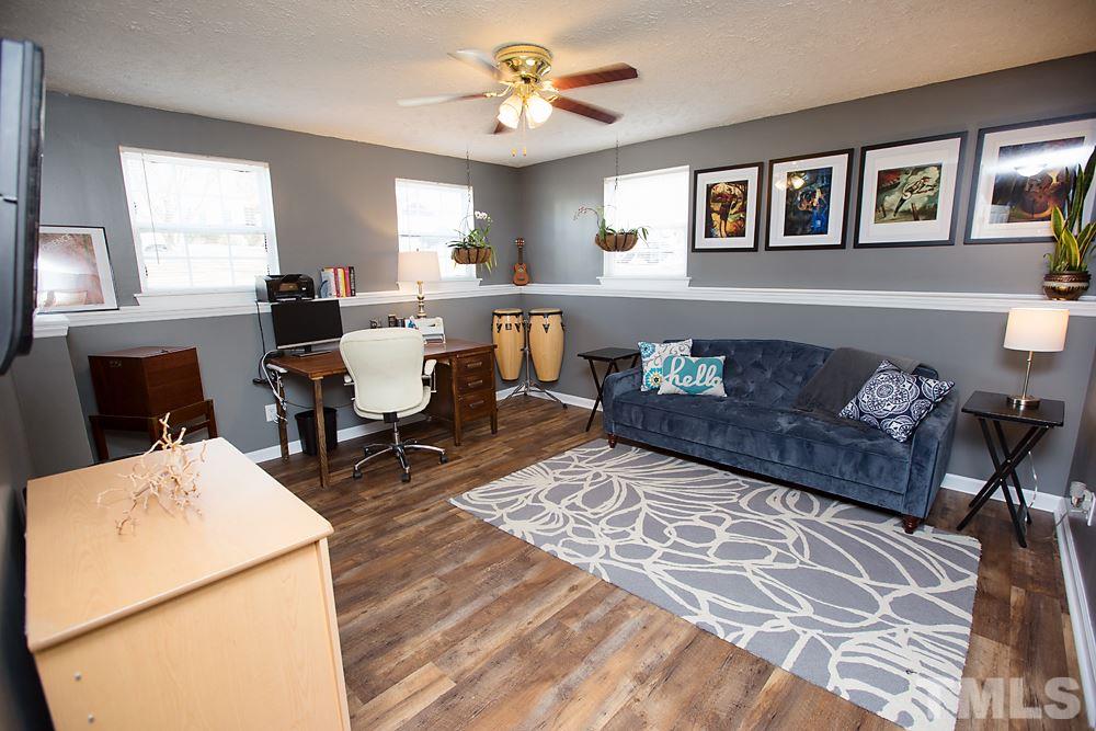 2225 Springhill Avenue Raleigh, NC 27603 - Photo 14 of 18 a living room with furniture and paintings on the wall
