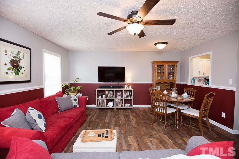 2225 Springhill Avenue Raleigh, NC 27603 - Photo 3 of 18 a living room with furniture and a flat screen tv with wooden floor