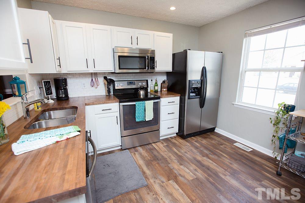 2225 Springhill Avenue Raleigh, NC 27603 - Photo 5 of 18 a kitchen with stainless steel appliances a stove a sink a refrigerator a window