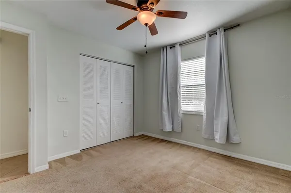 a view of a livingroom with a ceiling fan and window