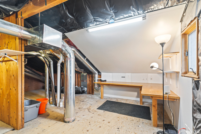 460 Omni Point Road Central Valley, UT 84754 - Photo 51 of 101 Finished attic space featuring exposed wood framing, built-in shelving, a wood-finish workbench, and a fixed window
