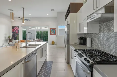 a kitchen with stainless steel appliances granite countertop a sink and a refrigerator