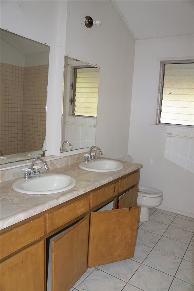 440 Mikioi Place Kihei, HI 96753 - Photo 16 of 28 a bathroom with a granite countertop sink a toilet and a mirror
