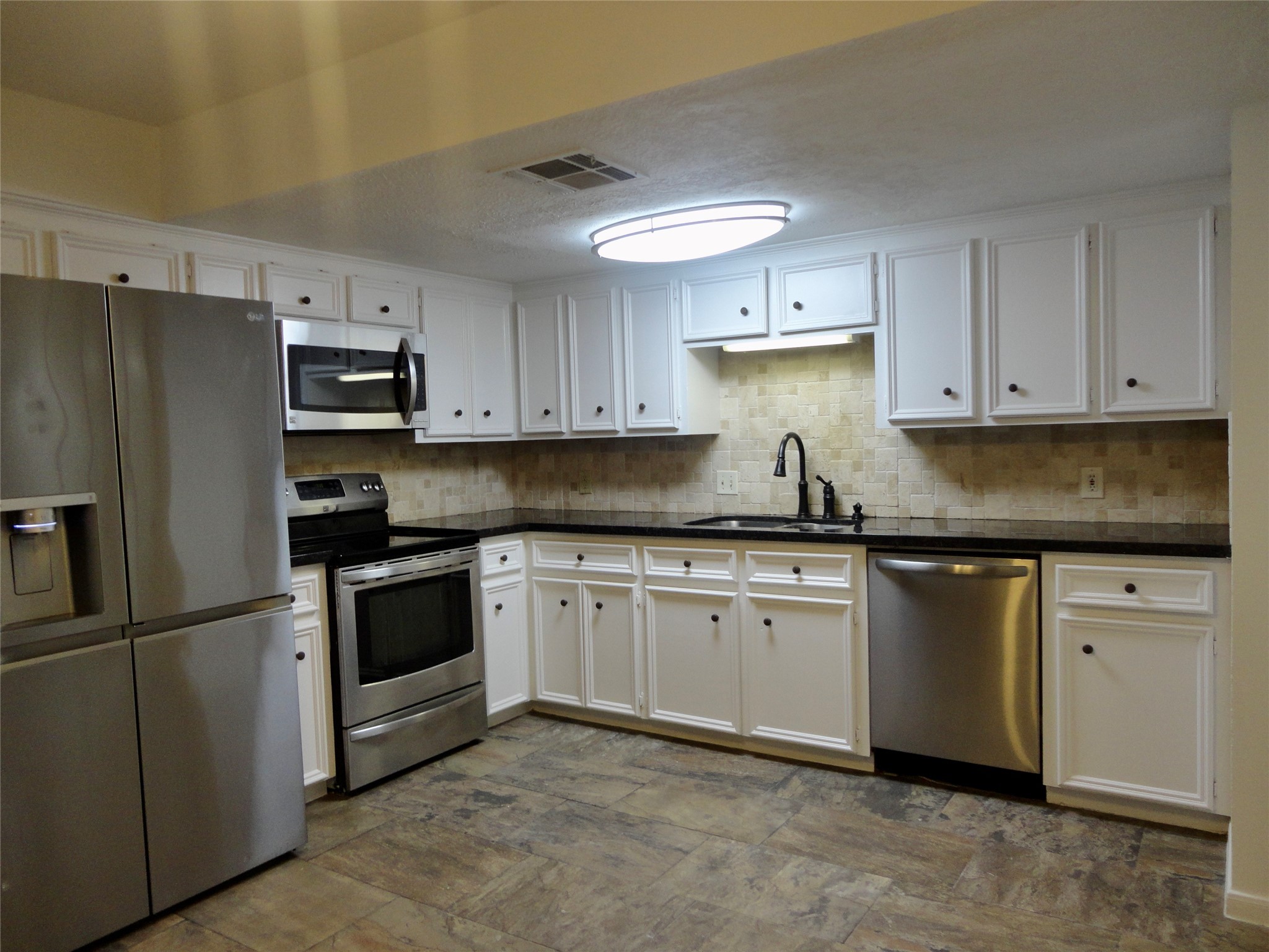 6700 Richardson Road, Unit 204 Houston, TX 77069 - Photo 2 of 39 a kitchen with granite countertop a refrigerator sink and white cabinets