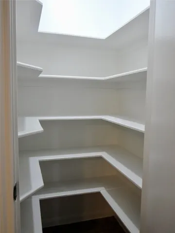 a view of a hallway with a livingroom and a bathroom with toilet