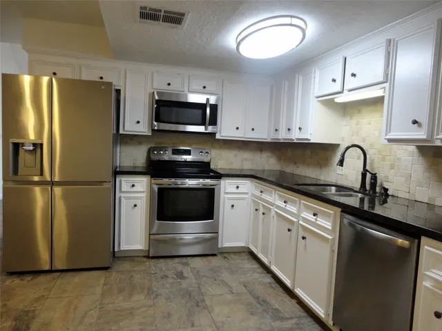 a kitchen with stainless steel appliances a refrigerator sink and cabinets