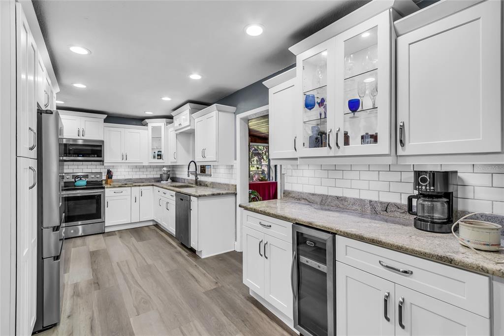 5012 West C 476 Bushnell, FL 33513 - Photo 11 of 42 a kitchen with granite countertop white cabinets and white appliances
