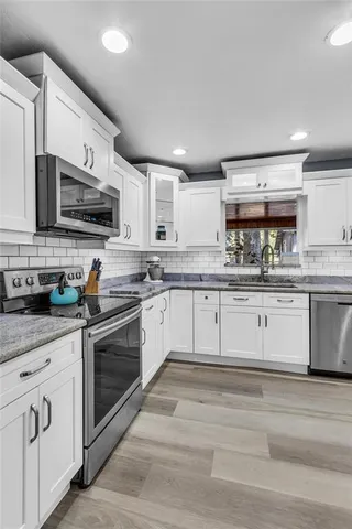 a kitchen with stainless steel appliances granite countertop a stove sink and cabinets