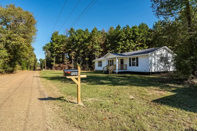 a view of a house with backyard and deck