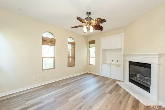 a view of an empty room with a window and fireplace