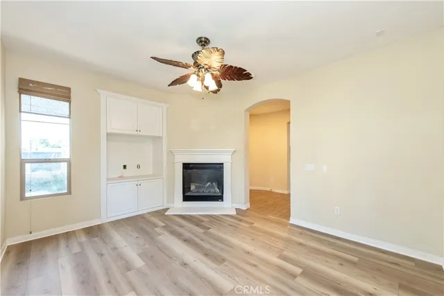a view of an empty room with a fireplace and a window