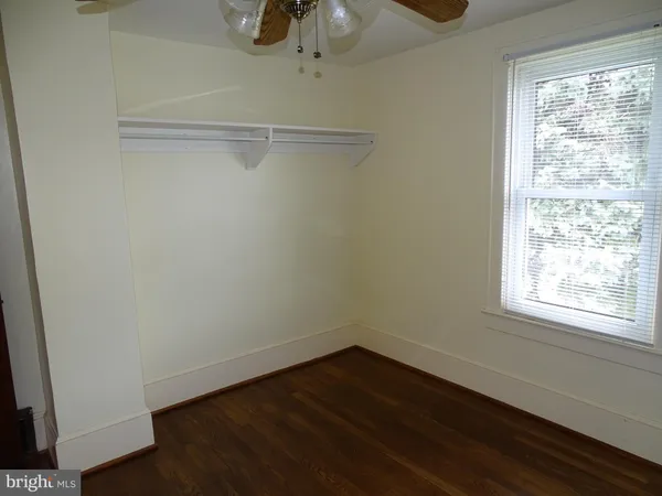 a view of a room with wooden floor closet and windows