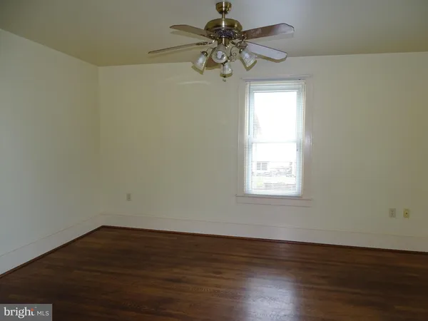 a view of a big room with wooden floor and windows