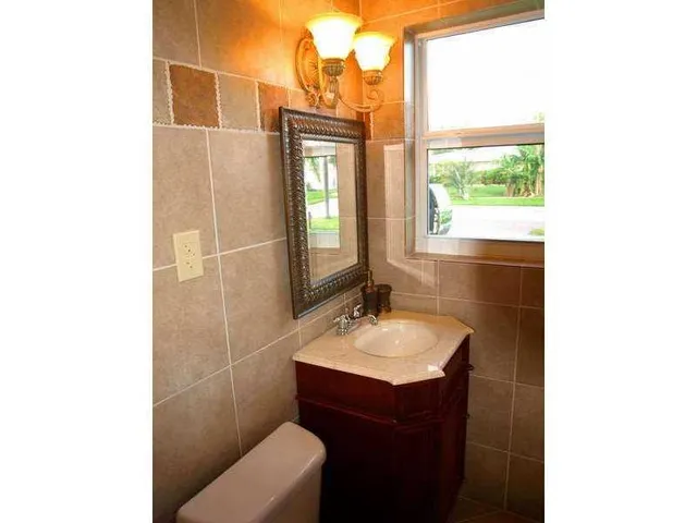 a bathroom with a sink toilet and mirror