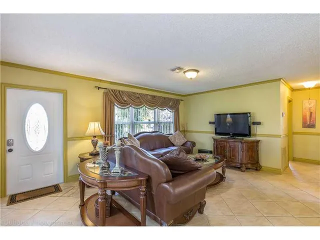 a living room with furniture a flat screen tv and a large window