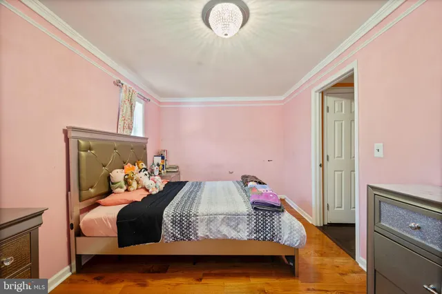 a bedroom with bed and wooden floor
