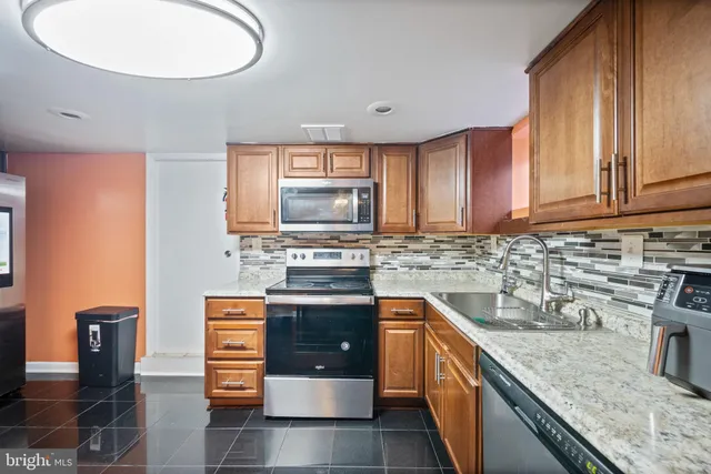 a kitchen with stainless steel appliances granite countertop a sink stove and cabinets