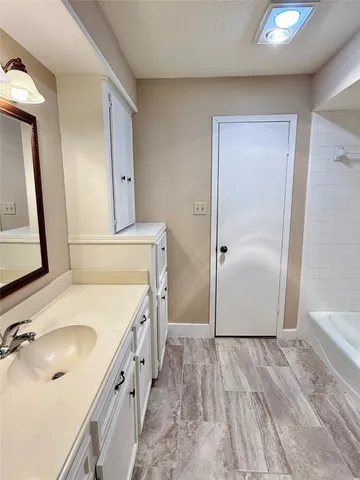 a bathroom with a granite countertop sink a mirror and shower