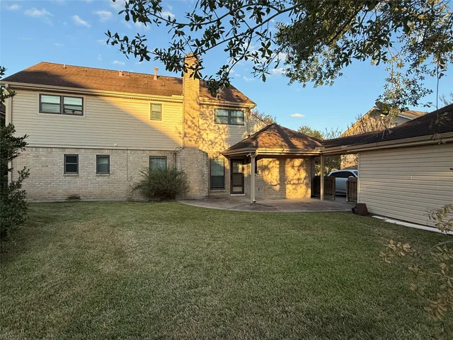 a view of a yard in front of a house with large trees