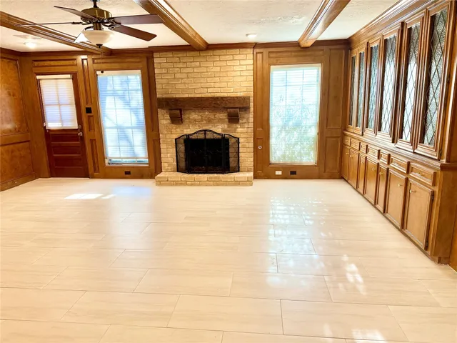 a view of an empty room with a fireplace and a window