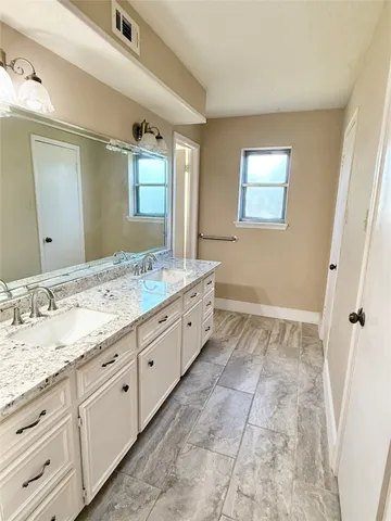 a spacious bathroom with a granite countertop sink a mirror and a