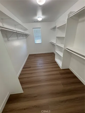 a view of an empty room with wooden floor and entryway