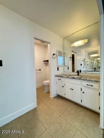 a bathroom with a granite countertop sink mirror and toilet
