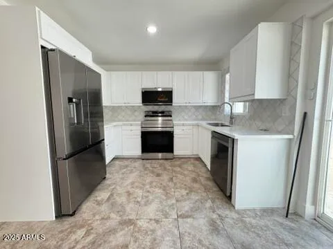 a kitchen with stainless steel appliances granite countertop a refrigerator sink and stove
