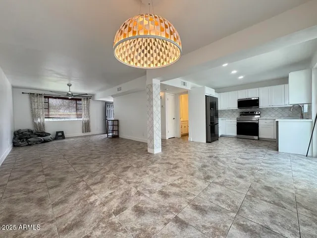 a view of a kitchen with granite countertop cabinets and chandelier