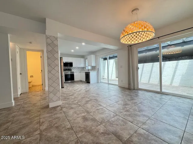 a view of an empty room and a kitchen