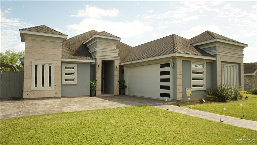 414 Ric Mar Street Edinburg, TX 78541 - Photo 2 of 36 Contemporary residence featuring a light-colored stucco and stone facade, a multi-paneled garage door, and multiple window designs