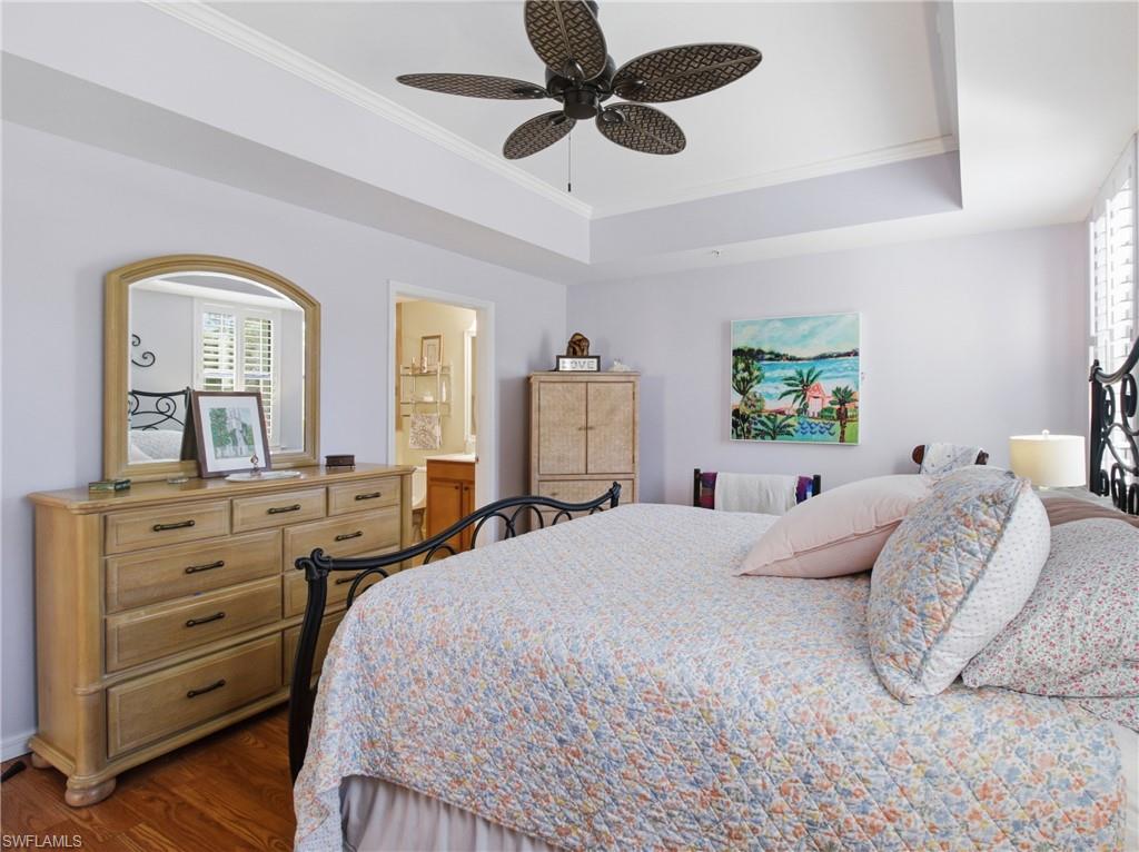 20161 Bravada Street, Unit 2 Estero, FL 33928 - Photo 15 of 34 Bedroom with ornamental molding, dark wood-style flooring, ensuite bath, ceiling fan, and a raised ceiling