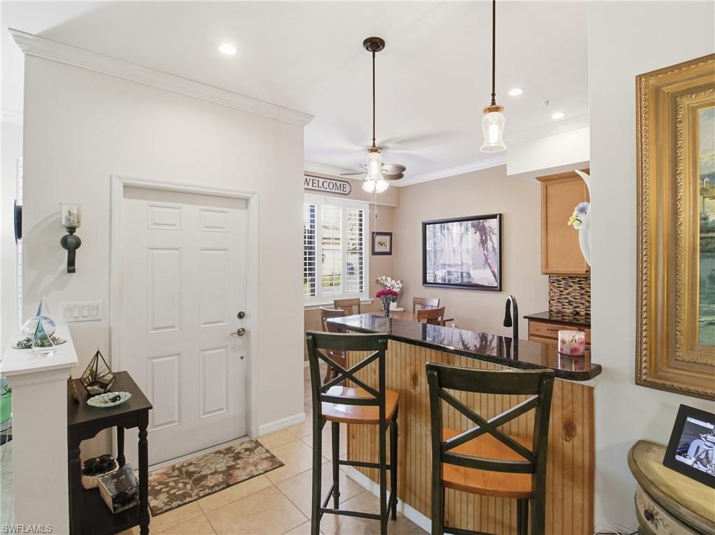 20161 Bravada Street, Unit 2 Estero, FL 33928 - Photo 9 of 34 Bar featuring tasteful backsplash, pendant lighting, a ceiling fan, light tile patterned floors, and dark stone counters